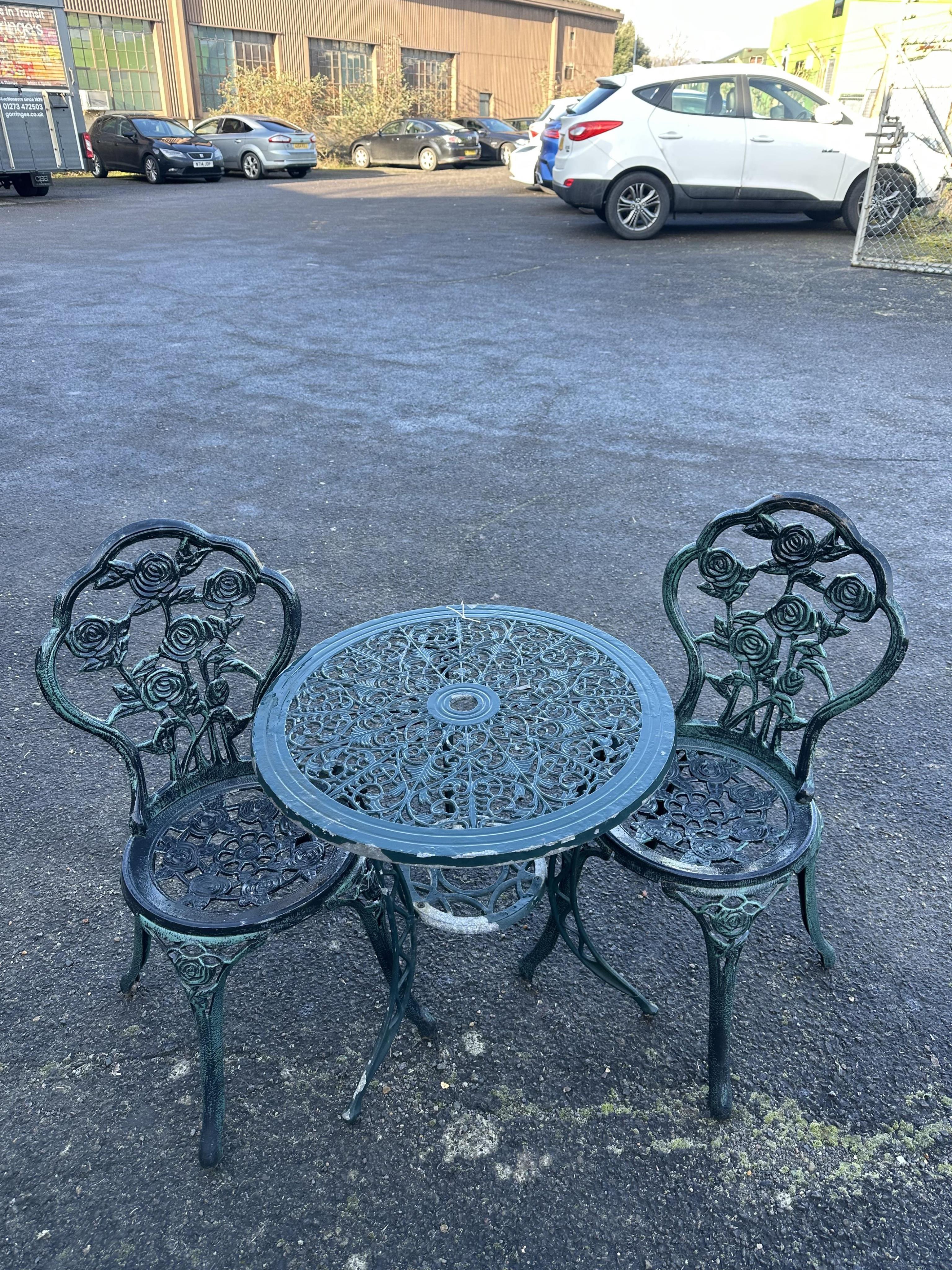 An aluminium garden table, diameter 60cm and a pair of chairs. Condition - poor